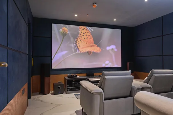 A media room featuring recliners, a sofa-cum-be and full acoustic paneling.